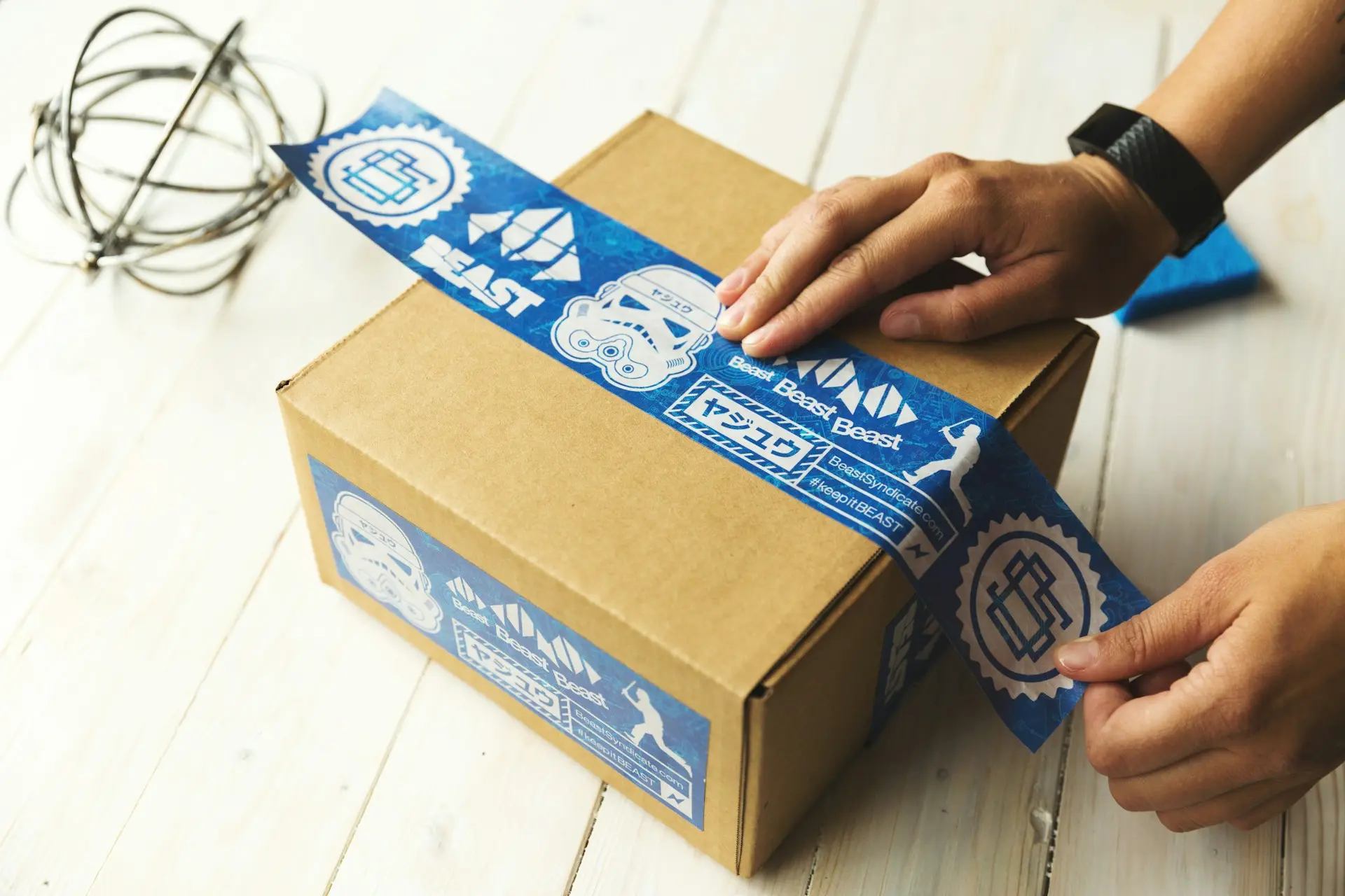 Versandvorbereitung: Hände verschließen ein Paket mit Klebeband